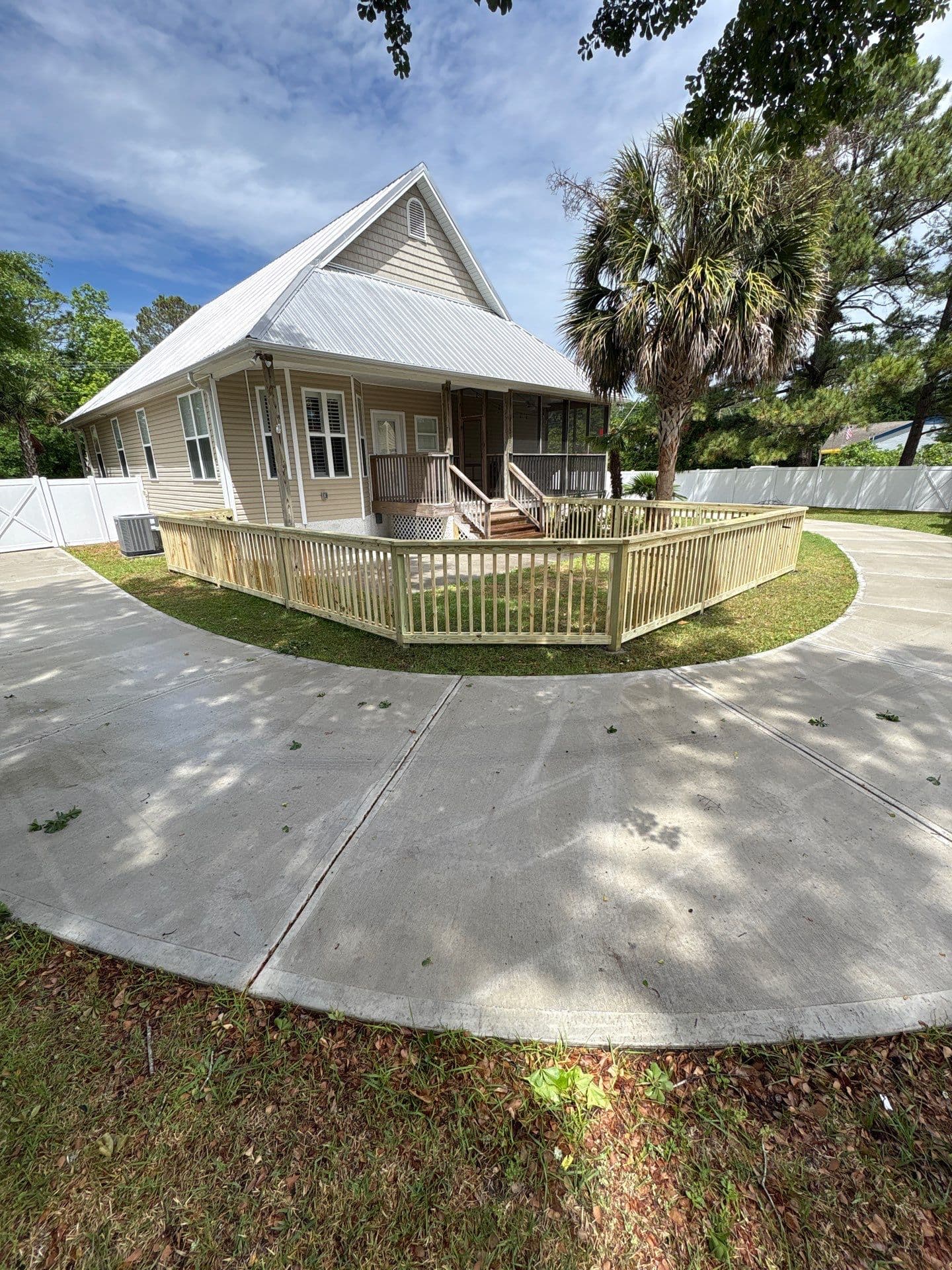 Low wood picket fence wrapping a circular driveway in the Wilmington, NC area