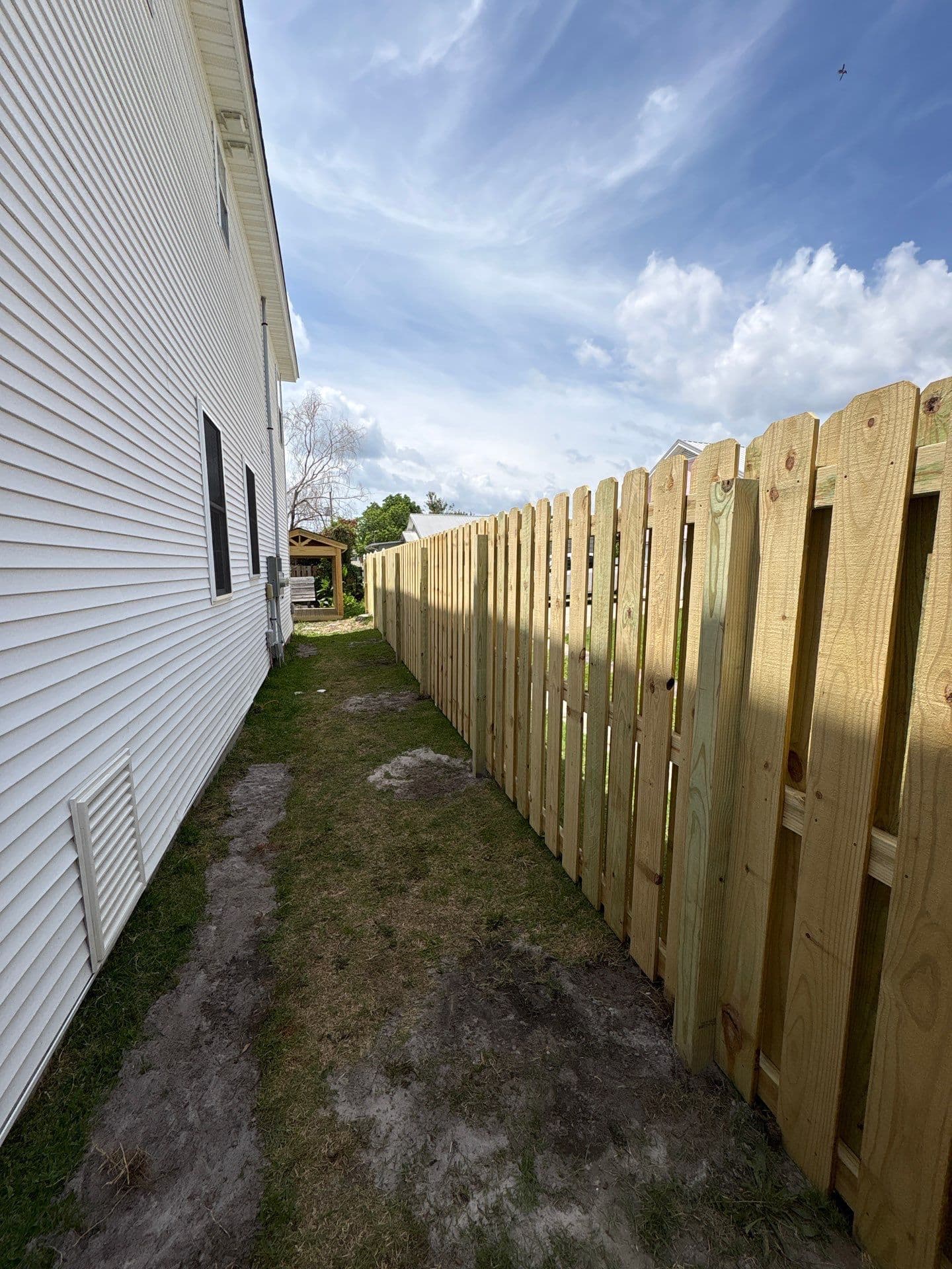 New shadowbox-style wood privacy fence along a side yard in the Wilmington, NC area