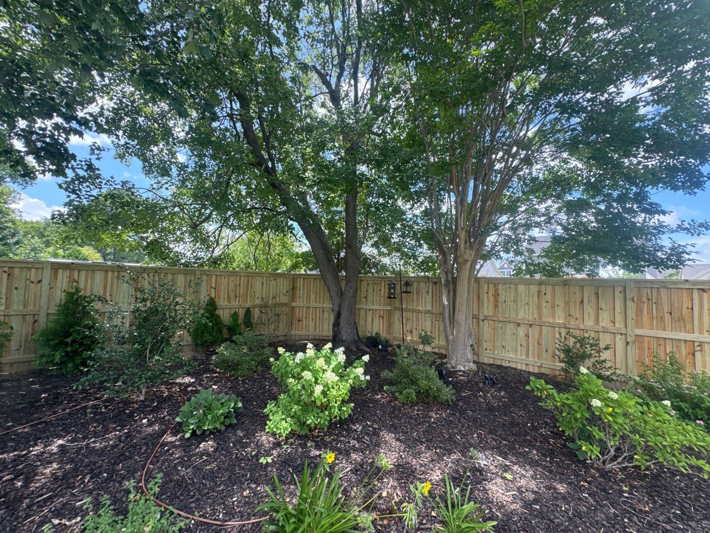 Wood privacy fence behind a landscaped garden in the Wilmington, NC area